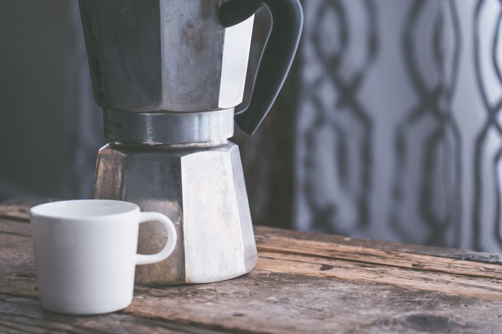 A mug in front of a coffee maker.