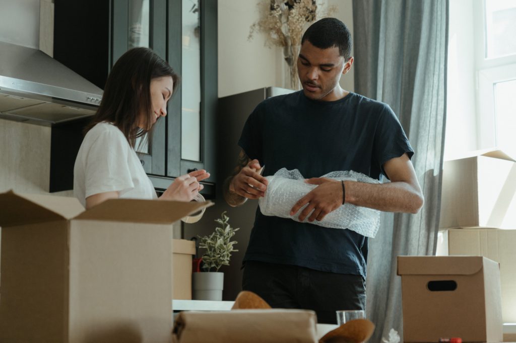 A person packing kitchen appliances in a box